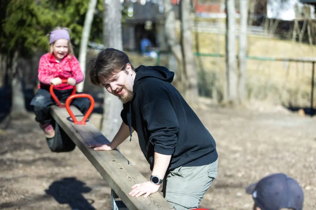 Bildet viser et barn på dumphuske og en voksen mann