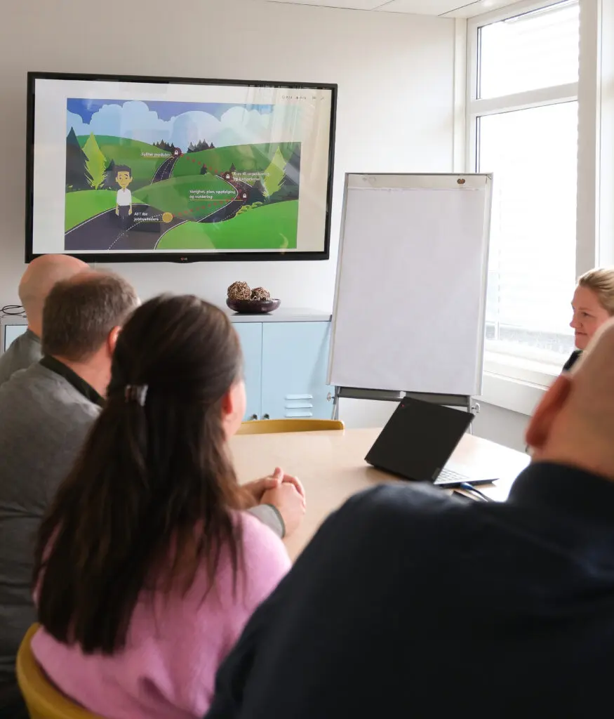 veiledere som sitter rundt et bord og ser på skjerm